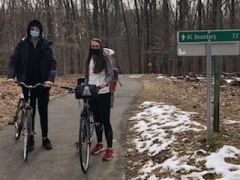 Carly Maas and a fellow student take their bikes to a research site in Rock Creek. 
