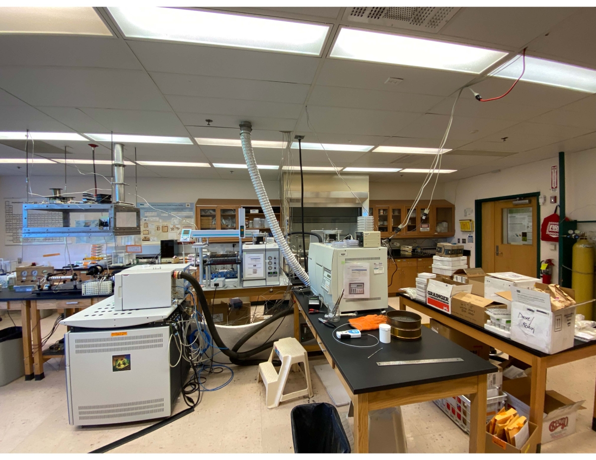 A scientific lab with large equipment and tables with boxes
