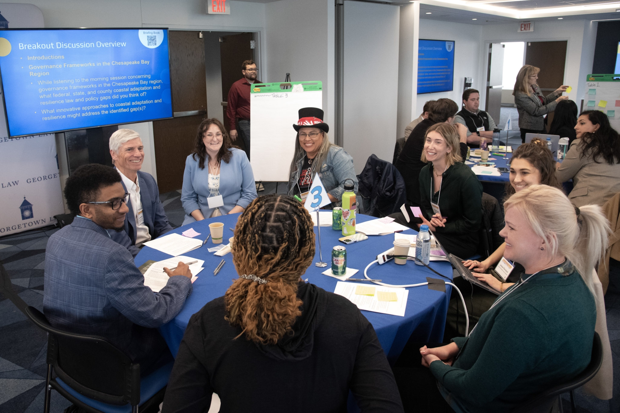 A group of people seated at a round table having a discussion during a law symposium