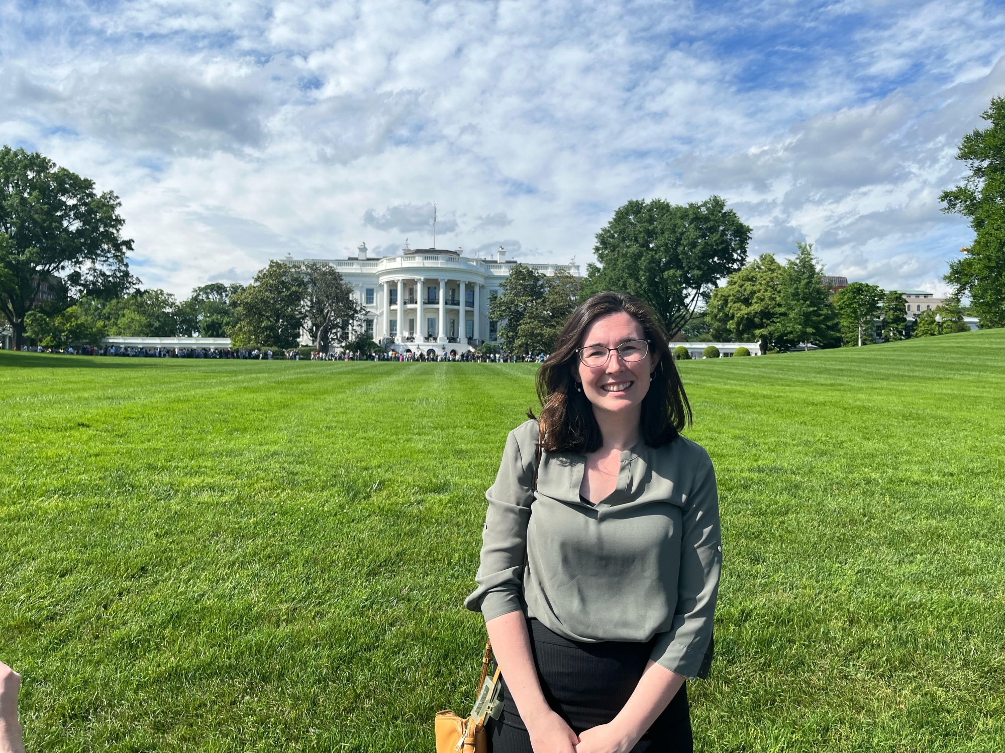 Portrait of Cassandra Worthington on a grassy lawn in Washington, DC, with a government building in the distance