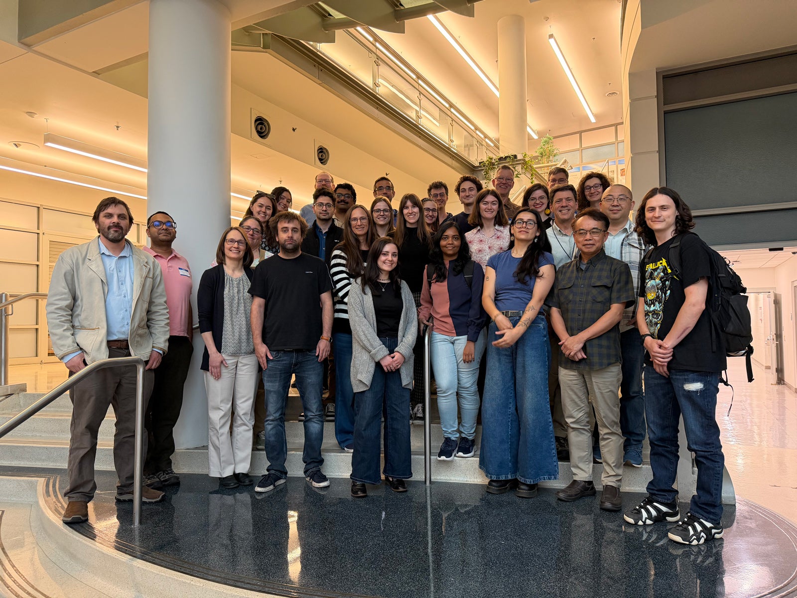 A group of researchers pose together on the steps at the entrance hall of the Institute of Marine and Environmental Technology building