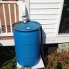 image of rain barrel conencted to home downspout