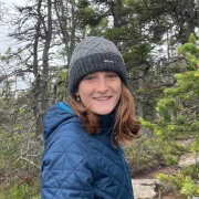 Julia Smeltzer with a winter hat and blue coat in a forest