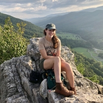 Dani Weissman sitting on rocks while hiking in Seneca Rocks, West Virginia