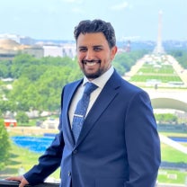 Abdulmajid Alrefaie stands on a balcony overlooking the National Mall and the Washington Monument