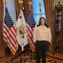 Kayle Krieg stands in front of flags.