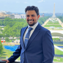 Man stands on a balcony overlooking the Washington Monument