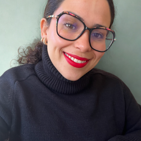 A young woman (Bruna Sobrinho) wearing a turtleneck sweater and glasses