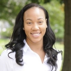 Headshot of woman smiling with outdoor background