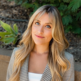 Headshot of woman smiling with outdoor background