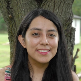 Paulina Huanca in front of a tree.