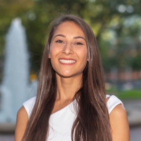 Brunette woman smiling wearing white shirt.