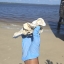 A gloved hand holding an oyster shell on a beach