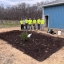 A group of watershed stewards academy students stand next to a newly installed rain garden