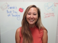Headshot of Sarah Cvach in front of a white board