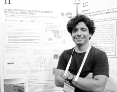 Daniel Teodoro with his poster on the importance of stakeholder satisfaction at a conference in The Netherlands.