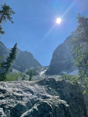 Mountains in Washington state with snow and conifer trees under a sunny blue sky 