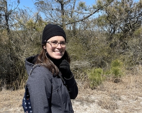 Portrait of Rachel Lamb outside with trees in background.