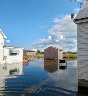 A house and shed are surrounded with floodwaters up to their foundations in Tylerton on Smith Island