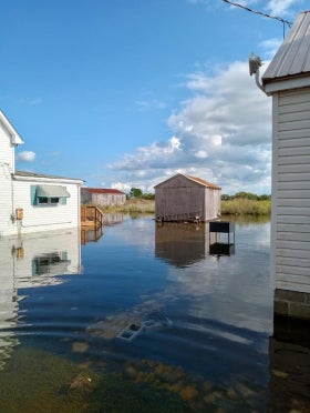 A house and shed are surrounded with floodwaters up to their foundations in Tylerton on Smith Island