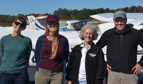 Cora Johnston, Julia Rentsch, Mary MacMutcheon, and Scott Lerberg in front of airplane