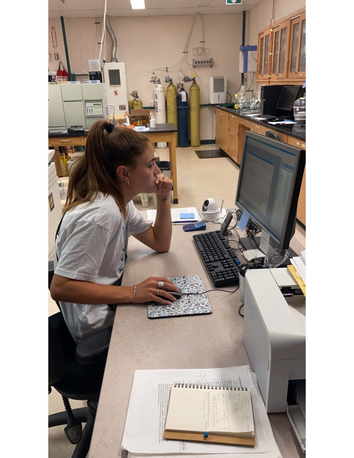 A research fellow works at a computer in a scientific lab