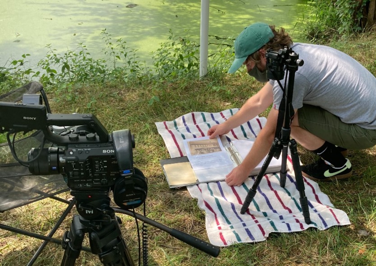 Logan setting up a photoshoot of historical documents outside."